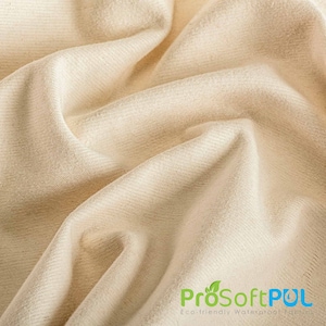 May include: Close-up of a cream-colored fabric with a subtle texture. The fabric is folded and draped, showcasing its soft and smooth surface. The text "ProSoftPUL Eco-friendly Waterproof Fabric" is visible in the lower right corner.