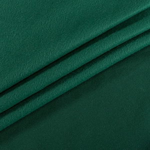 May include: Close-up of a deep green fabric with a soft, fuzzy texture. The fabric is folded in a diagonal pattern, creating a textured surface.