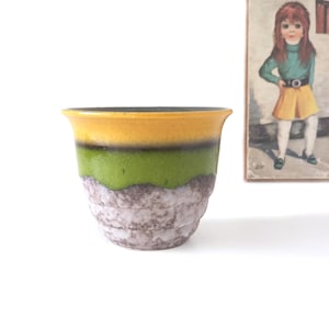 May include: A set of three ceramic mugs with a speckled, matte finish. The mugs are in shades of cream, light gray, and dark gray. Each mug has a simple, minimalist design, perfect for coffee or tea.