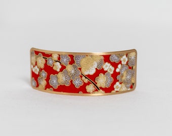 Barrette decorated with Japanese washi paper with cherry blossoms on a red background