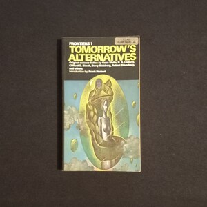 May include: A book cover with a green frog and a woman inside a bubble. The book title is "Tomorrow's Alternatives" and the subtitle is "Original science fiction by Gene Wolfe, R. A. Lafferty, Clifford D. Simak, Barry Malzberg, Robert Silverberg, and others. Introduction by Frank Herbert."