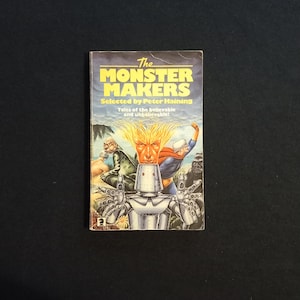 May include: A paperback book cover with a colorful illustration of a robot and other characters. The title of the book is "The Monster Makers" and the subtitle is "Selected by Peter Haining. Tales of the believable and unbelievable!"