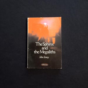 May include: A book cover with an orange background and a silhouette of a person in front of a sunset. The title of the book is "The Sphinx and the Megaliths" by John Ivimy. The book is published by Abacus.