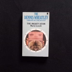 May include: A book cover with a blue background and white text. The title is "The Mighty Atom" by Marie Corelli. The book is part of the Dennis Wheatley Library of the Occult.