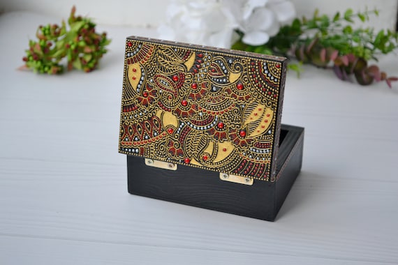 A small wooden jewelry box hand-decorated with intricate Henna/Mehndi art — 149 favorites proves this golden-pattern keepsake genuinely stops scrollers.