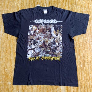 Puede incluir: Camiseta negra con un estampado gráfico de una banda llamada "Carcass" y el texto "Reek of Putrefaction".