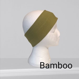 May include: Olive green headband made of bamboo fabric, shown on a white mannequin head. The word "Bamboo" is printed in black at the bottom of the image. This headband is designed to keep hair out of the face.