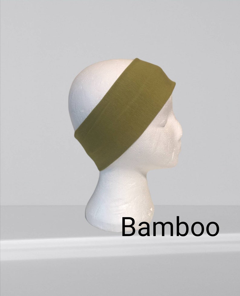 May include: Olive green headband made of bamboo fabric, shown on a white mannequin head. The word "Bamboo" is printed in black at the bottom of the image. This headband is designed to keep hair out of the face.