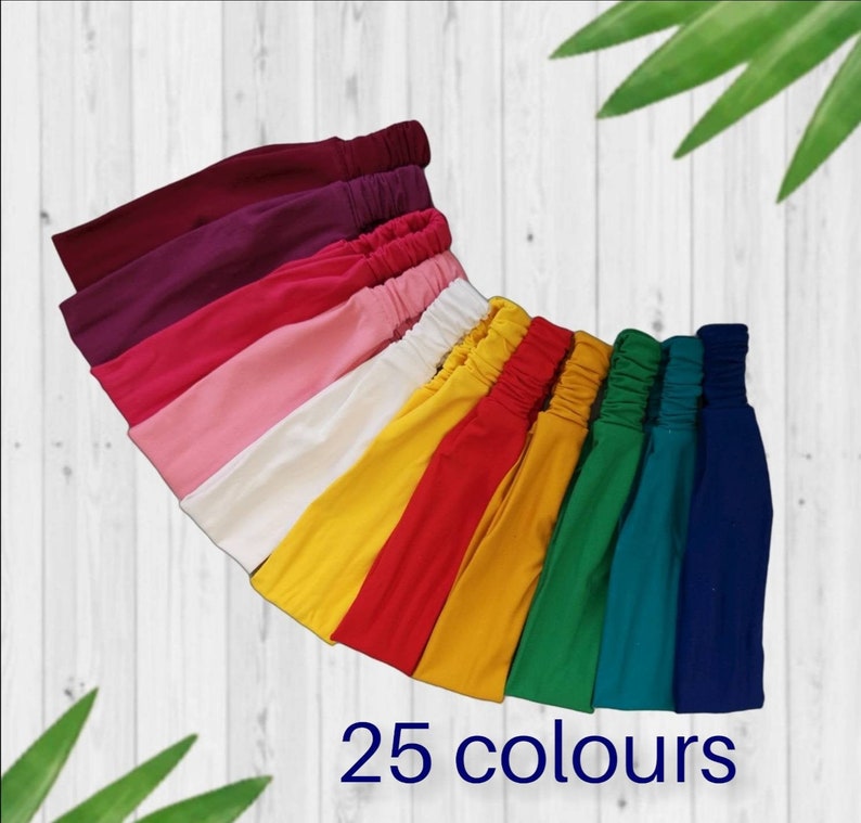 May include: A collection of 25 colorful headbands in various shades of pink, red, yellow, green, and blue. The headbands are made of a soft, stretchy fabric and are perfect for adding a pop of color to any outfit.