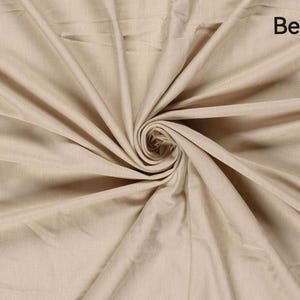 May include: Beige fabric with a swirling pattern. The fabric is a light tan color, with the word "Beige" in the upper right corner. The fabric is folded and draped, creating a spiral effect in the center.