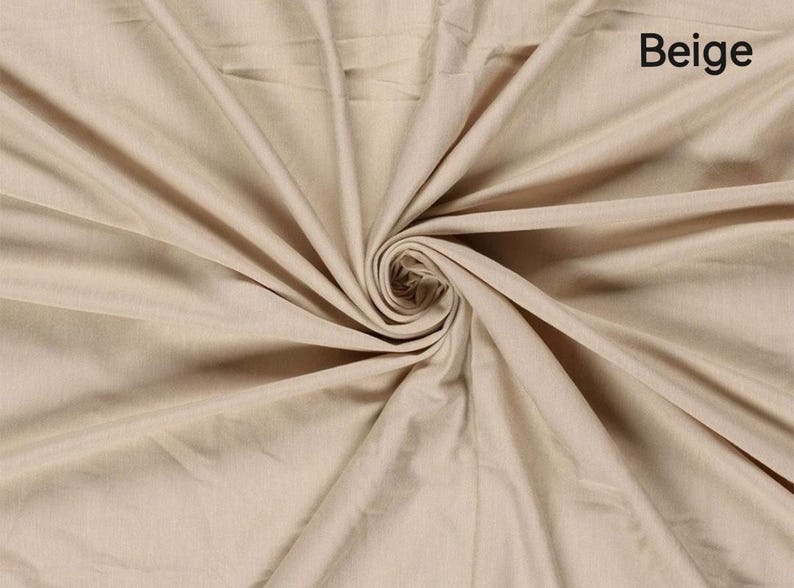 May include: Beige fabric with a swirling pattern. The fabric is a light tan color, with the word "Beige" in the upper right corner. The fabric is folded and draped, creating a spiral effect in the center.