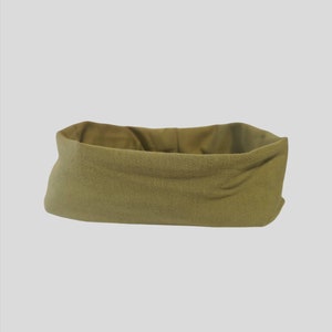 May include: A rectangular, olive green fabric basket with a folded-over top. The basket has a textured appearance and a neutral color, suitable for various storage purposes. The interior is a lighter shade of olive green.