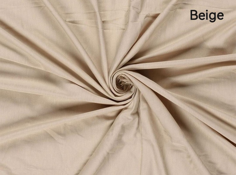 May include: Beige fabric with a swirling pattern. The fabric is a light tan color, with the word "Beige" in the upper right corner. The fabric is folded and draped, creating a spiral effect in the center.