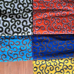 Peut inclure: Plusieurs pièces de tissu colorées avec un motif de tourbillon répétitif. Les tissus sont de différentes couleurs, notamment blanc avec des tourbillons verts, orange avec des tourbillons violets, bleu avec des tourbillons marron et jaune avec des tourbillons noirs.