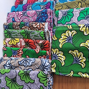 Peut inclure: Une pile de tissus à motifs colorés. Les tissus présentent des motifs floraux et géométriques audacieux dans une variété de couleurs, notamment le bleu, le vert, le rouge et le jaune. Le tissu est soigneusement plié et empilé, mettant en valeur les motifs vibrants.