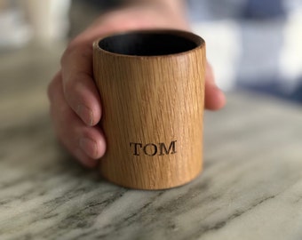 Puede incluir: Un vaso de chupito de madera personalizado con el nombre "TOM" grabado en el lateral.