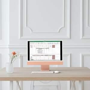 Op de afbeelding: Een roze gouden iMac-computer met een wit toetsenbord en muis op een licht houten bureau. Het computerscherm toont een spreadsheet met gegevens en grafieken.