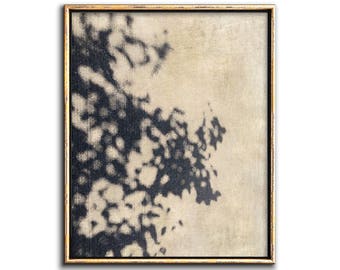 May include: Abstract art painting in a gold frame. The painting features a black and white design with a large, abstract shape in the center.