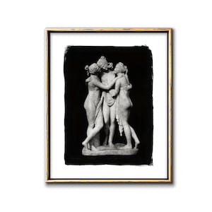 May include: Black and white photograph of a marble sculpture of three women embracing. The sculpture is set against a black background.