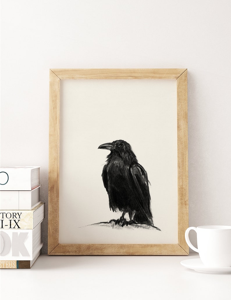 May include: A black and white drawing of a raven perched on a branch. The raven is facing to the right and has a detailed, realistic appearance. The drawing is framed in a light wood frame.