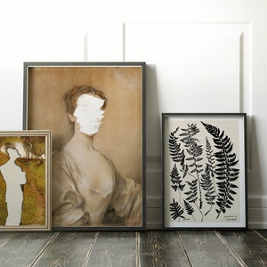 May include: Three framed prints on a white wall with a black chair in the foreground. The print on the left is a landscape with a person standing in the middle. The print in the centre is a portrait of a woman with her face obscured by white paint. The print on the right is a black and white botanical illustration of ferns.