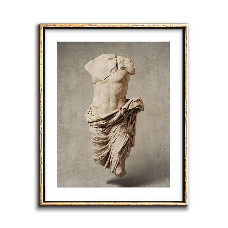 Pu&ograve; includere: Una scultura in marmo bianco di un torso maschile, drappeggiato in un panno, su uno sfondo grigio neutro.