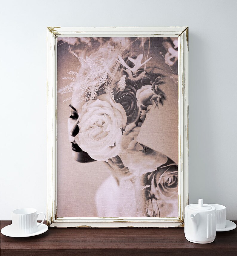 May include: A sepia-toned photograph of a woman's face with a large white rose covering her eye. The woman's face is partially obscured by the rose and other flowers. The image is framed in a white frame.