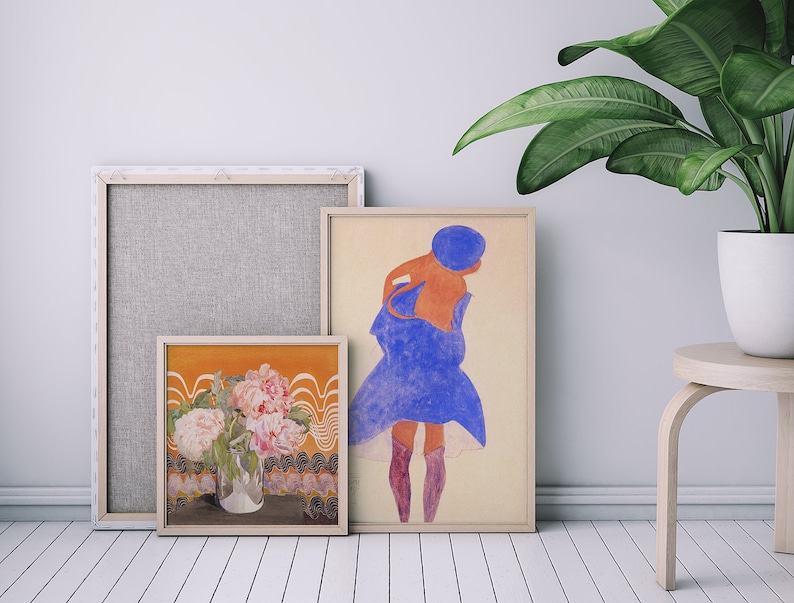 May include: Three framed art prints, one with a floral still life, one with a woman in a blue dress, and one with a textured background.