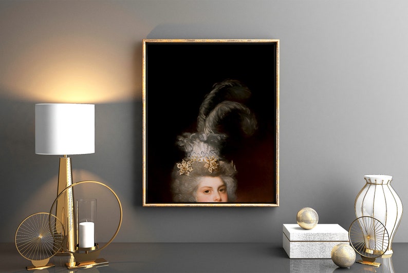 May include: A framed portrait of a person with powdered hair and a feathered headdress. The artwork is in a gold frame and hangs on a grey wall. The image is part of a home decor collection.