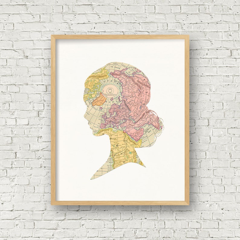 May include: A framed print of a silhouette of a person's head with a vintage world map overlayed on the silhouette. The map is in shades of pink, yellow, and blue.
