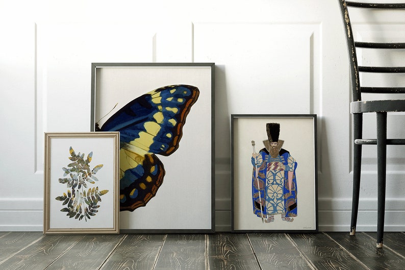 May include: Three framed prints on a wooden floor. The leftmost print features a collage of green leaves. The center print features a blue and yellow butterfly wing. The rightmost print features a man in a blue and gold patterned robe holding a staff.