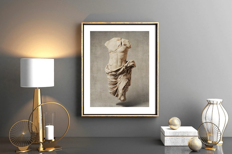 Pu&ograve; includere: Una stampa incorniciata di una scultura in marmo bianco di un torso con un panno drappeggiato. La scultura &egrave; su uno sfondo beige. La cornice &egrave; dorata.