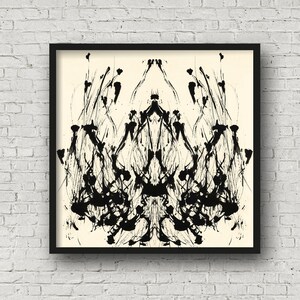 K&ouml;nnte beinhalten: Schwarz-wei&szlig;es abstraktes Tintenbild mit symmetrischem Design. Das Kunstwerk ist in einem schwarzen Rahmen gerahmt und hat einen cremefarbenen Hintergrund.