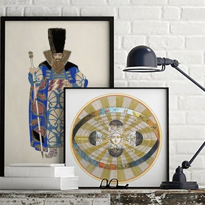 May include: Two framed prints on a white brick wall. The print on the left features a man in a blue and gold patterned robe holding a staff. The print on the right features a circular illustration of a geocentric model of the solar system.
