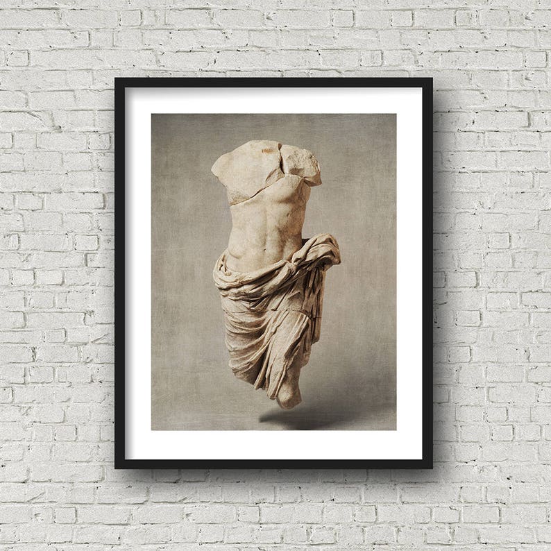Pu&ograve; includere: Una fotografia in bianco e nero di una statua di marmo di un torso di una persona. La statua &egrave; priva di testa e braccia. La statua &egrave; avvolta in un panno.