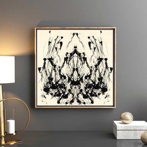 K&ouml;nnte beinhalten: Ein abstraktes Schwarzwei&szlig;bild in einem goldenen Rahmen h&auml;ngt an einer grauen Wand. Das Bild ist symmetrisch und zeigt eine Reihe von schwarzen Linien und Formen, die an eine Krone oder einen Baum erinnern. Das Bild ist von einem goldenen Rahmen umgeben und an einer grauen Wand ausgestellt.