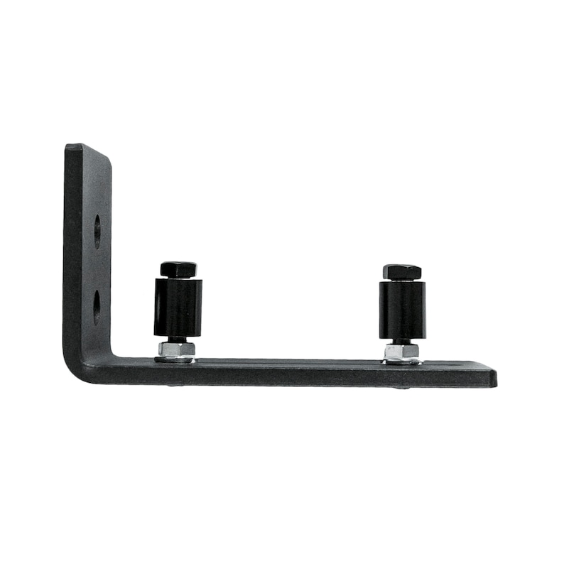 May include: Black metal bracket with two black rollers and silver screws. The bracket is designed to be mounted to a wall or floor.