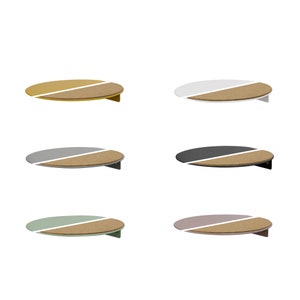 Könnte beinhalten: Sechs runde Wandregale mit einer Korkoberfläche und einer farbigen Unterseite. Die Regale sind in den Farben Gelb, Weiß, Grau, Schwarz, Grün und Rosa.