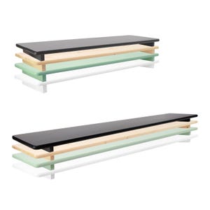 Könnte beinhalten: Zwei Wandregale. Das obere Regal ist schwarz, das mittlere Regal ist aus Naturholz und das untere Regal ist hellgrün. Die Regale werden von weißen Halterungen getragen. Das Design ist minimalistisch und modern.