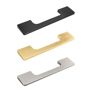 Könnte beinhalten: Drei moderne Schrankgriffe in Schwarz, Gold und Silber. Jeder Griff hat einen rechteckigen Körper mit einem gebogenen Griff, der für einfaches Greifen konzipiert ist. Die Hardware wird vor einem weißen Hintergrund gezeigt.