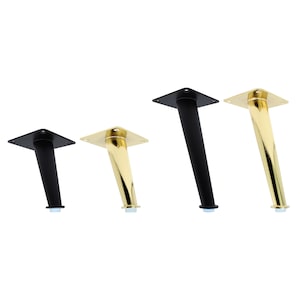 Op de afbeelding: Vier meubelpoten in verschillende maten. Twee zijn zwart en twee zijn goud.