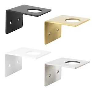 Pode incluir: Quatro saboneteiras de metal em diferentes acabamentos: preto, dourado, branco e prata. Cada saboneteira tem um recorte redondo para o sabonete e dois furos para montagem.