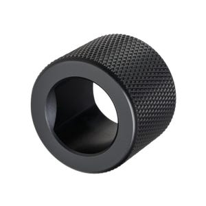 Pode incluir: Um objeto cilíndrico preto com uma superfície texturizada com padrão de losangos. O objeto tem uma abertura circular no centro e um acabamento liso e fosco. O design sugere um componente mecânico ou industrial.