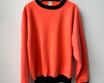 Bluza z okrągłym dekoltem z lat 80./90. z frotte francuskiej z czesanym tyłem. Wyblakły fluorescencyjny pomarańczowy. Pudełkowy, super wygodny krój. Rozmiar L.