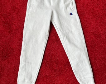 Współczesne białe spodnie dresowe Champion Joggers. Wykonane z bawełnianego dżerseju o odwrotnym splocie. Sz S. Wyprodukowano w Salwadorze.