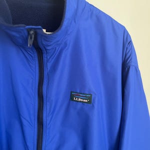 May include: A blue fleece lined jacket with a zipper closure and a black L.L.Bean logo patch.