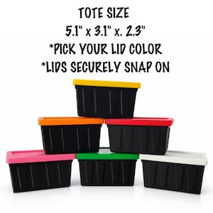 May include: Stack of six black storage containers with colored lids: yellow, orange, red, pink, green, and white. The text on the image reads: TOTE SIZE 5.1" x 3.1" x. 2.3" *PICK YOUR LID COLOR *LIDS SECURELY SNAP ON.