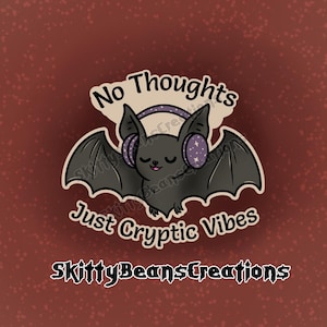 May include: A sticker featuring a cartoon bat with headphones. The bat has closed eyes and is wearing purple headphones with stars. Text reads "No Thoughts Just Cryptic Vibes" and "SkittyBeansCreations". The background is a reddish-brown color.