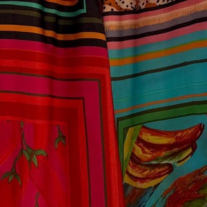 Puede incluir: Tejido vibrante con patrones audaces. La imagen muestra secciones de textiles coloridos, con fondos rojos, rosas, azules y negros, adornados con dise&ntilde;os florales y abstractos. Los textiles tienen una apariencia sedosa.