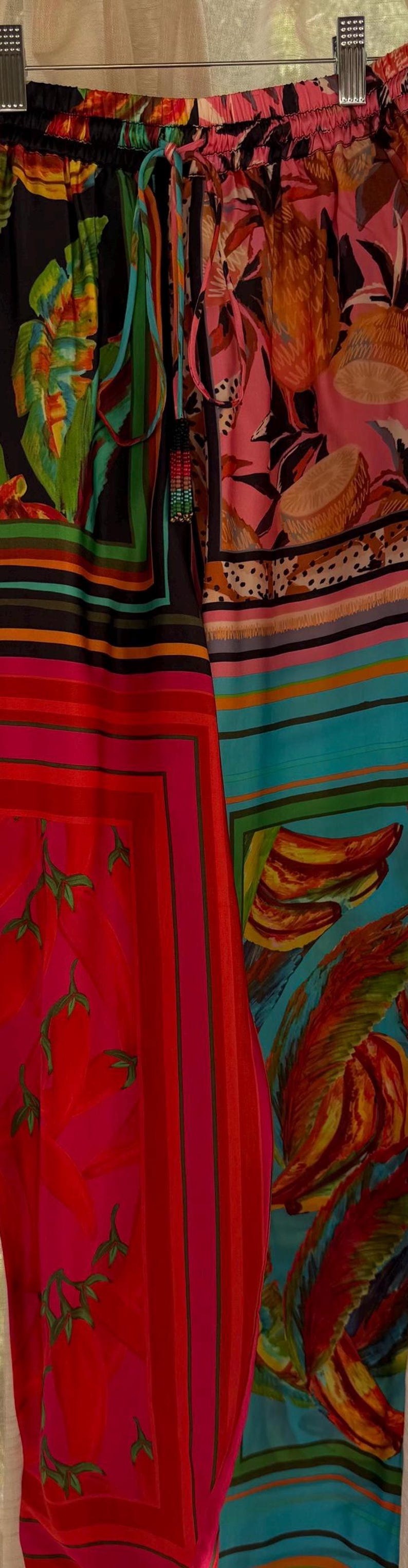 Puede incluir: Tejido vibrante con patrones audaces. La imagen muestra secciones de textiles coloridos, con fondos rojos, rosas, azules y negros, adornados con dise&ntilde;os florales y abstractos. Los textiles tienen una apariencia sedosa.